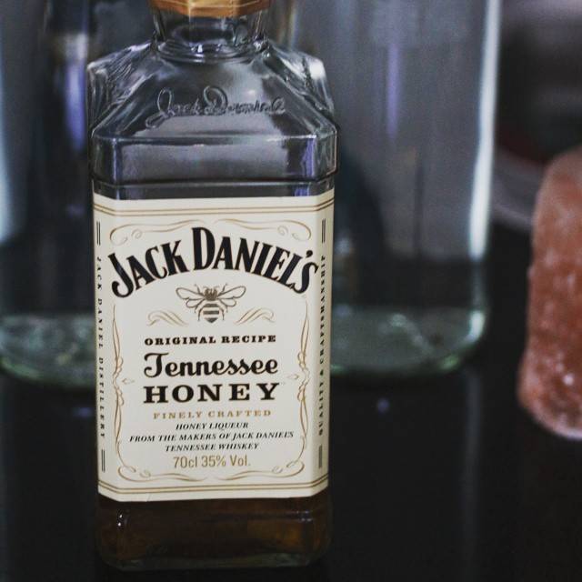 A bottle of Jack Daniel's Tennessee Honey liqueur on a bar counter.