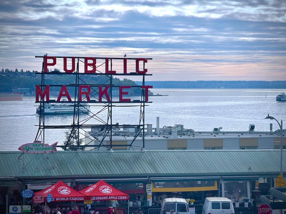 The Public Market sign at Pike Place, with the Puget Sound and ferries in the background