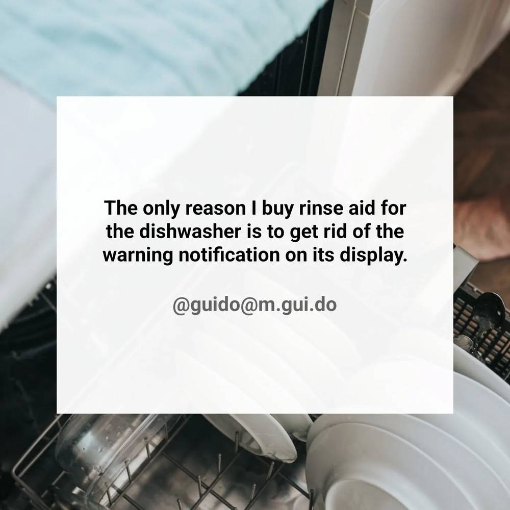 A text graphic over a photo of an open dishwasher, joking about buying rinse aid just to silence its warning light.