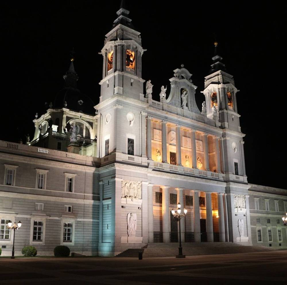 The illuminated Almudena Cathedral in Madrid at night.