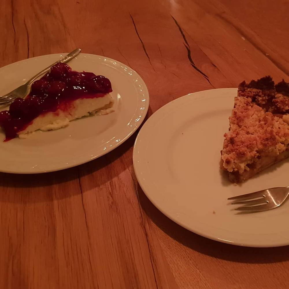 Two dessert plates on a table, one with a fruit compote slice and one with a crumble slice.