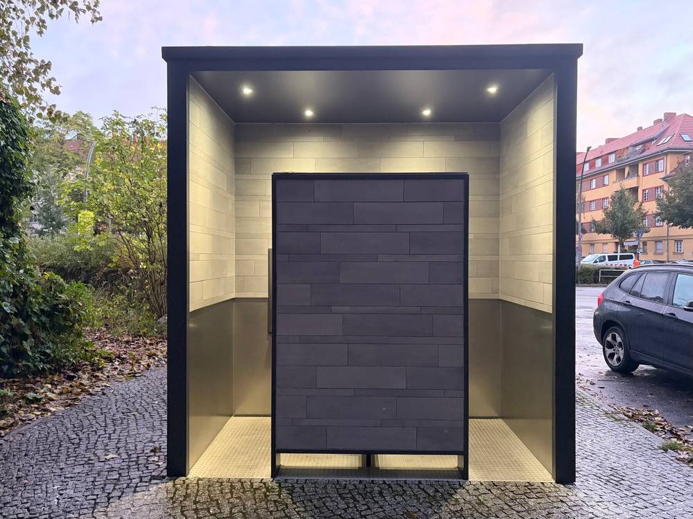 beleuchtetes klohaus am rand der rehberge das durch die perspektive wie ein portal in eine schönere welt aussieht