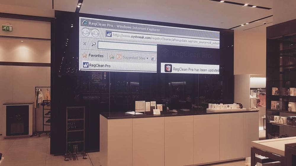 A retro tech exhibit showing an old Internet Explorer browser window on a screen above a store display counter.