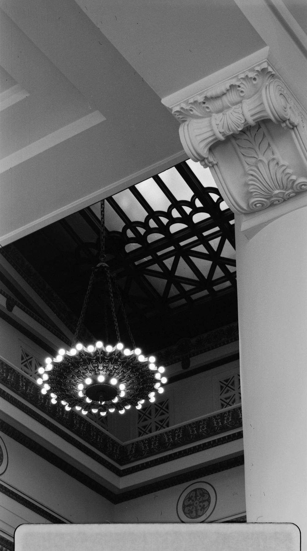A chandelier framed by ornate trim 