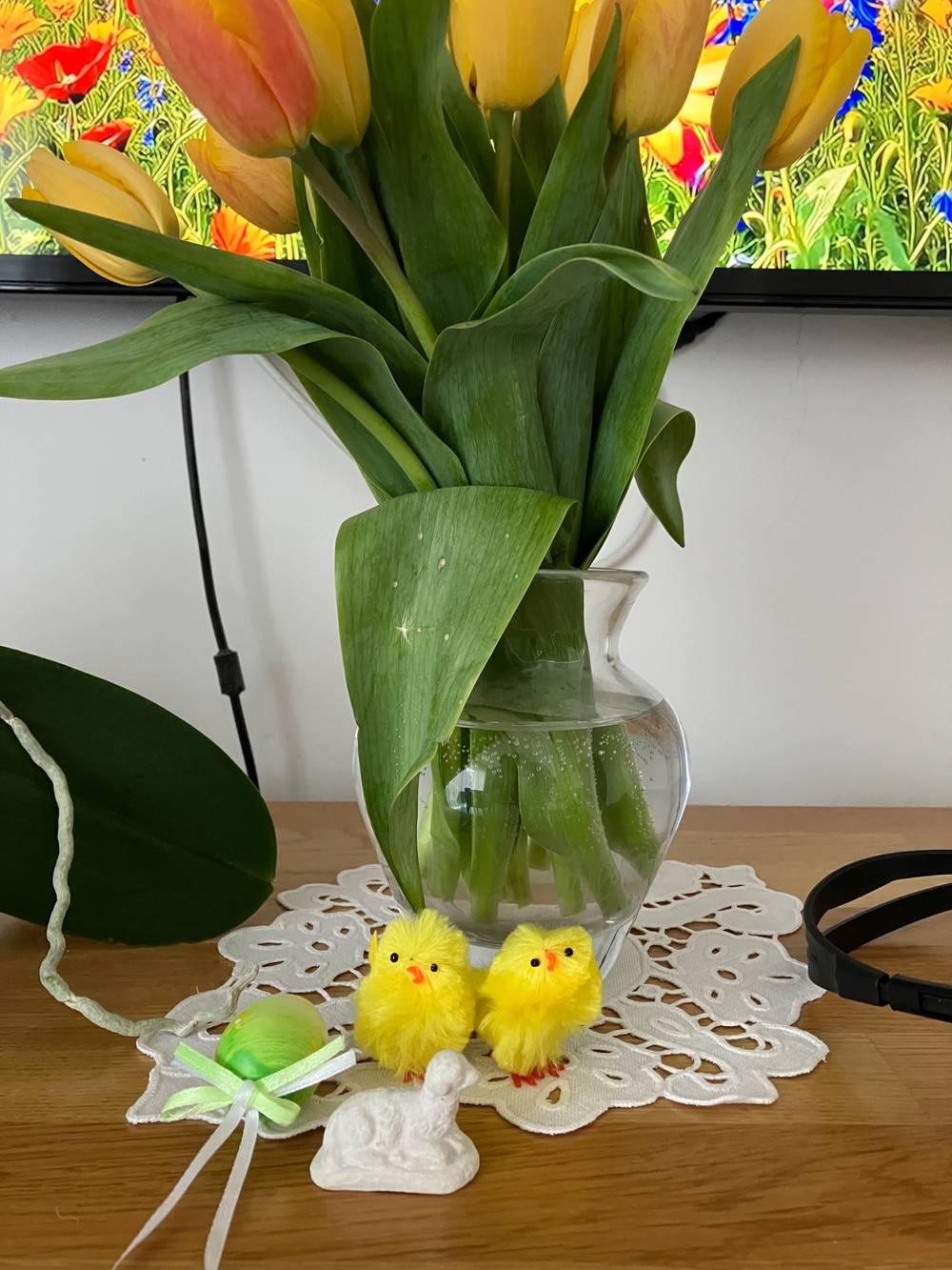 Flower vase with tulips and two small yellow chick toys in front of it