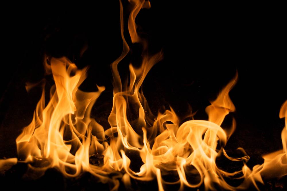 A close-up of orange flames rising against a black background.