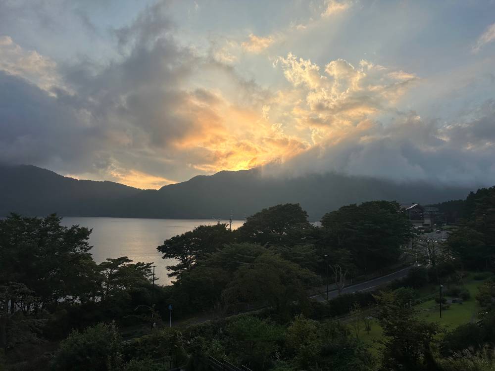 The view of lake Ashinoko from the Hanaori hotel, golden sky, sliver of lake, green acres and Japanese cedar for days.