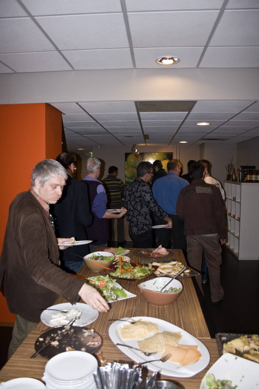 Attendees fill their plates at a buffet lunch spread during a conference.