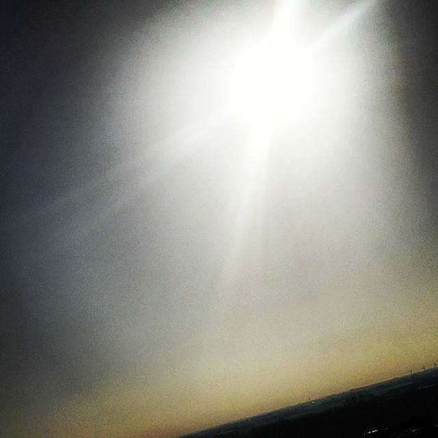 Bright sunlight breaking through a hazy, overcast sky.