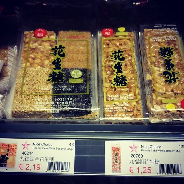Packaged peanut cakes on a supermarket shelf with price tags in euros.