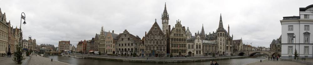 A wide panorama of Gent's historic guild houses lining the canal.