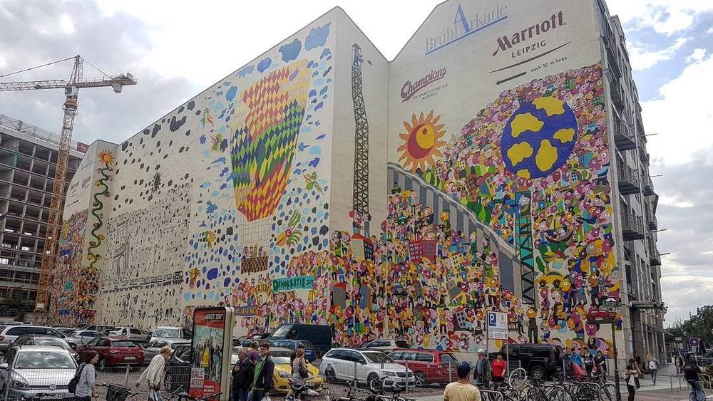 A colourful mural covering the exterior of a large building near a Marriott hotel.