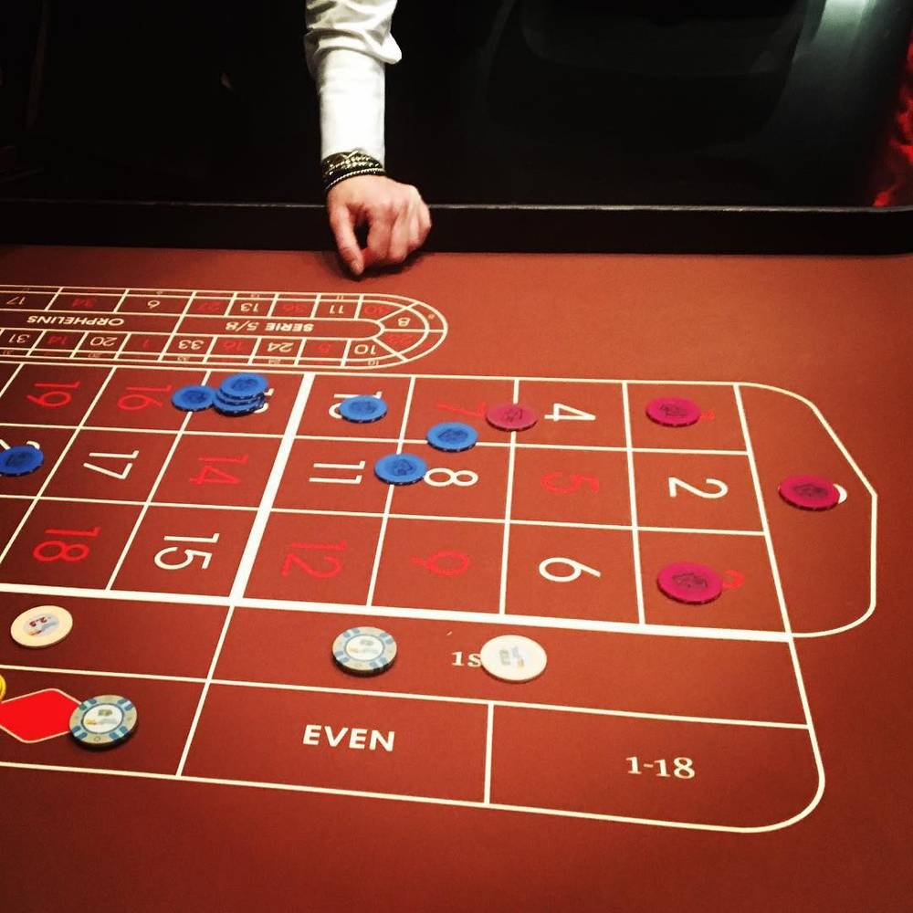 A roulette table with betting chips placed on numbers and the "even" section.