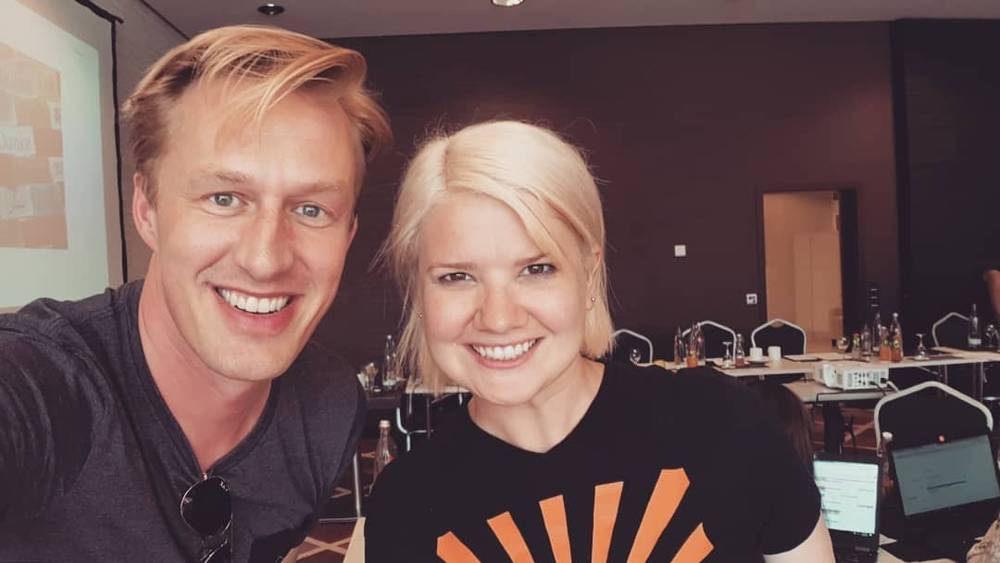 Two people smiling for a photo at a conference workshop.