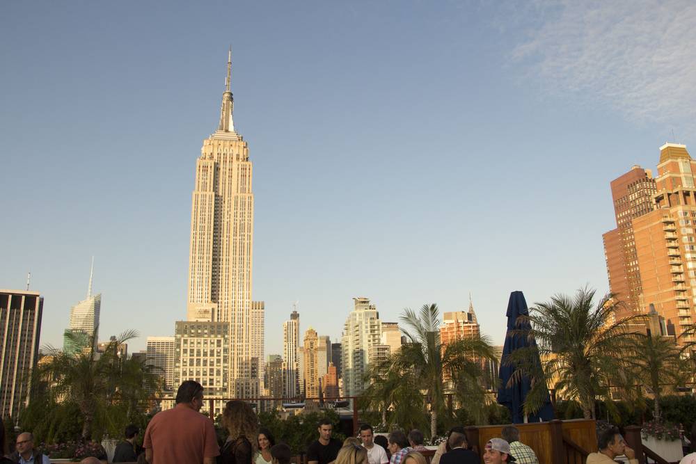 The Empire State Building glows at sunset, seen from the rooftop bar.