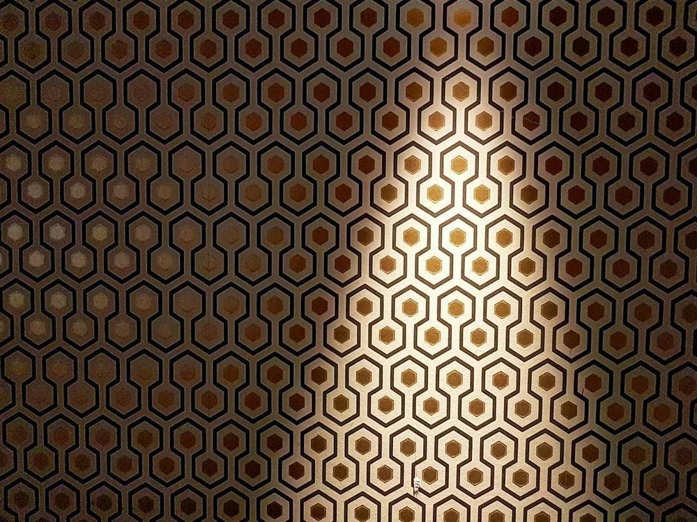 Close-up of a hexagonal patterned carpet lit from above.