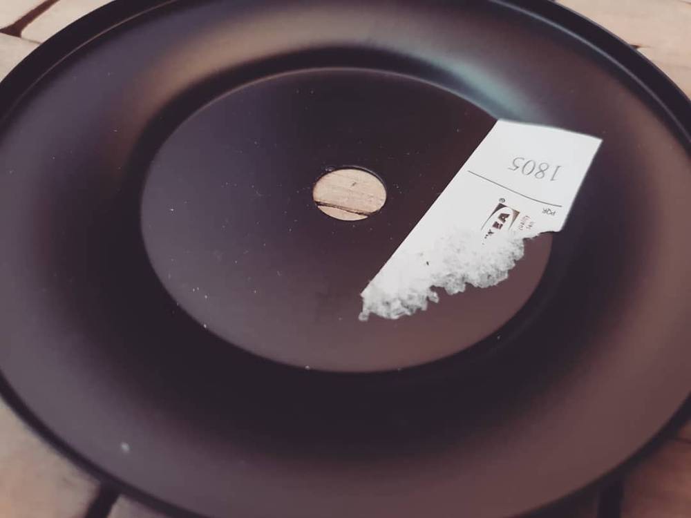 A small pile of white powder and a folded note on a round table.