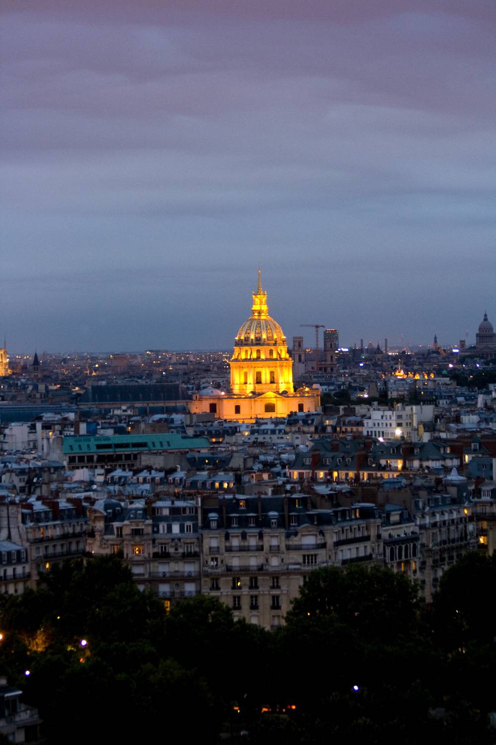 The golden dome of Les Invalides glows at dusk above the Paris skyline.