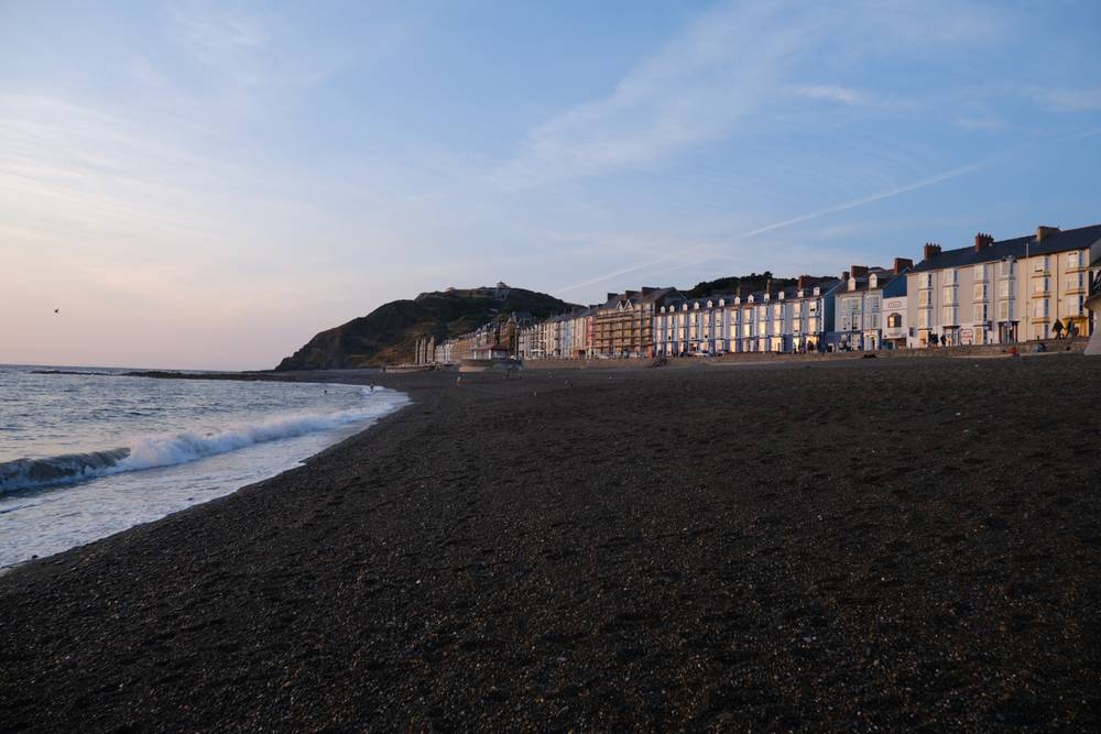 A picture of Aberystwyth's beach, looking down the promenade towards the cliff railway.