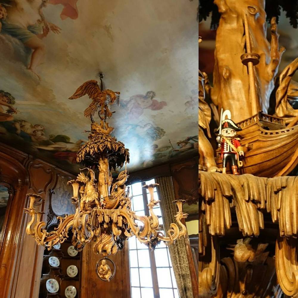 Collage of an ornate painted ceiling and a gilded ship figurine inside a historic building.