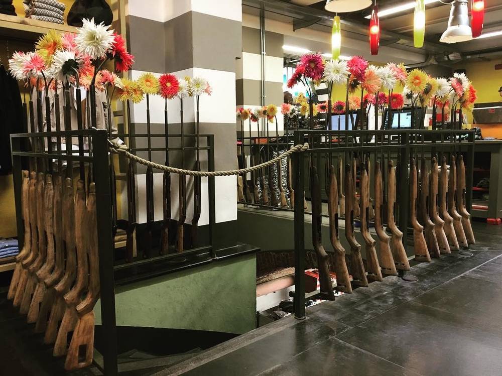 A row of decorative flower arrangements displayed along a railing inside a venue.