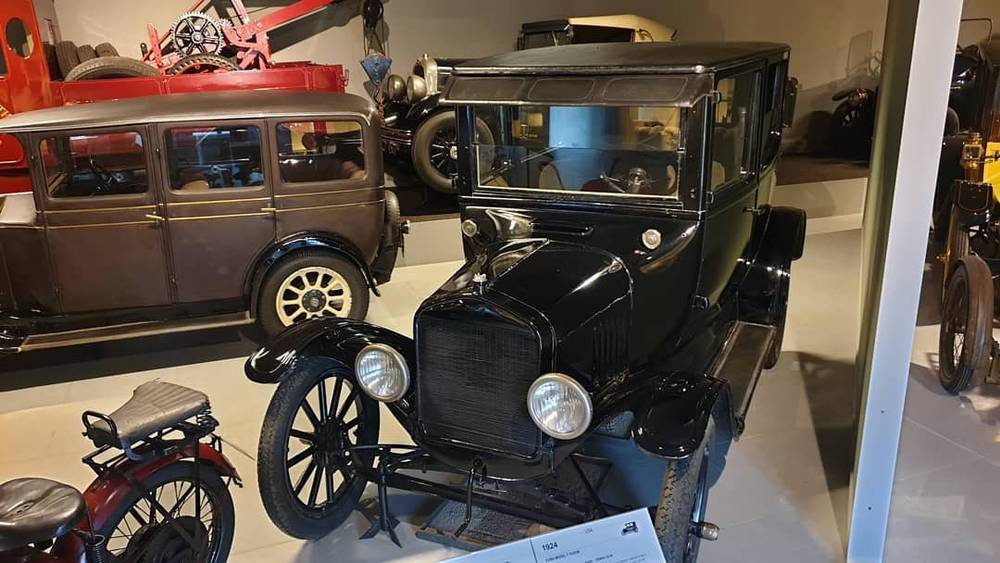A vintage black Ford Model T style car displayed in a car museum.