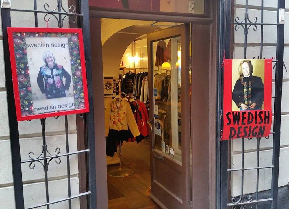 A shop entrance displaying "Swedish Design" posters and clothing racks inside.