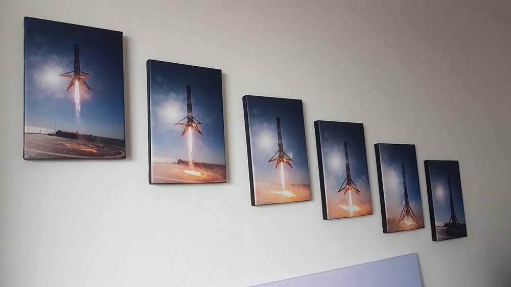 A row of framed rocket launch photographs displayed on a wall in decreasing size.