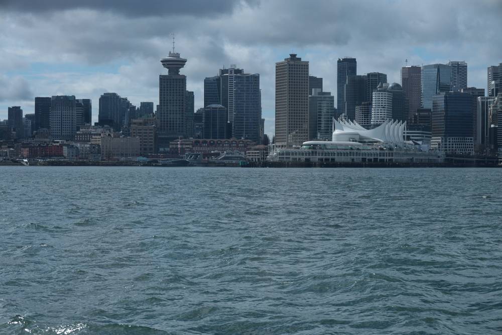 The Vancouver skyline seen across the water under cloudy skies.