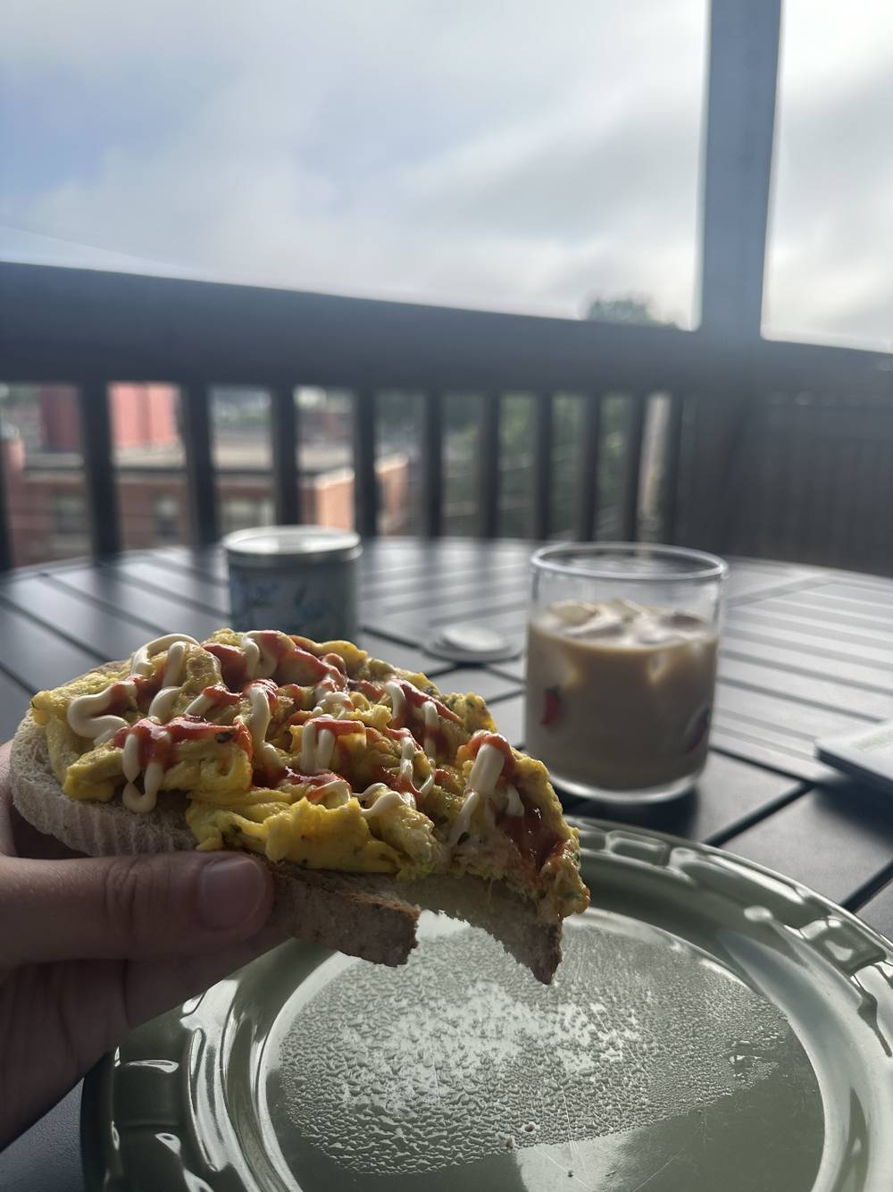 Scrambled eggs on toast with kewpie mayo and siracha drizzle. and a cold brew iced coffee. 