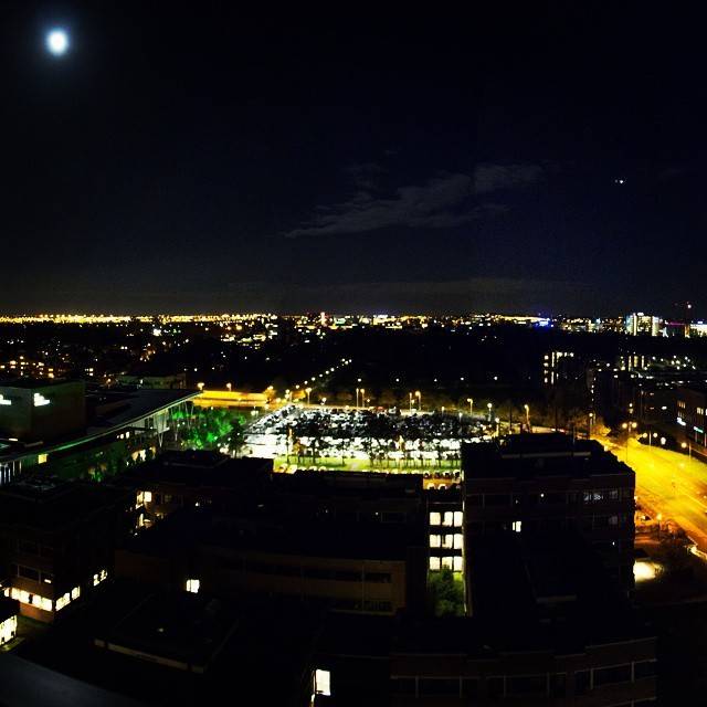 A city skyline lit up at night, viewed from above.