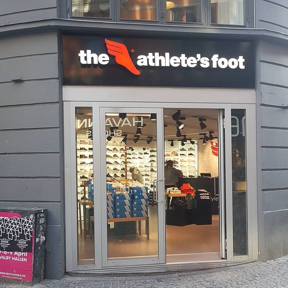 The storefront of "The Athlete's Foot" shoe shop with a display of sneakers.