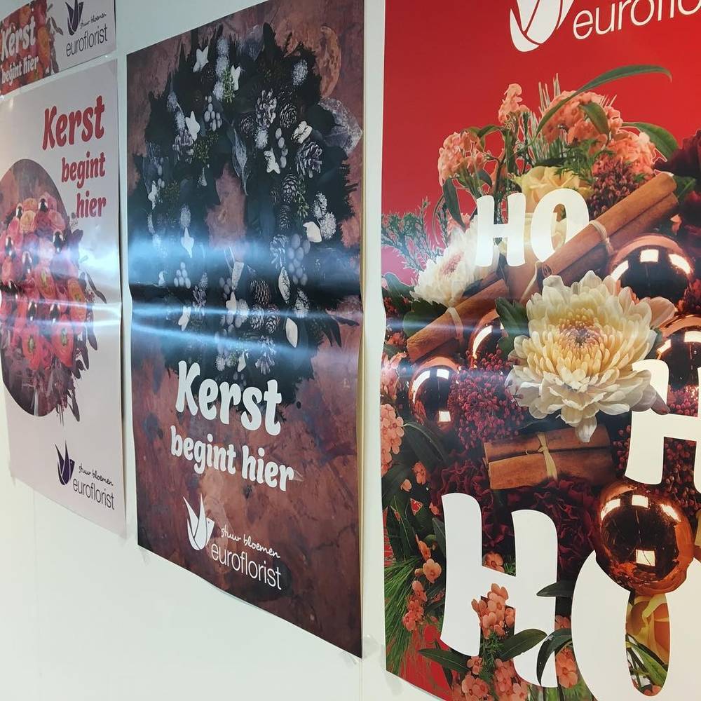 Christmas-themed advertising posters for Euroflorist reading "Kerst begint hier" (Christmas starts here).