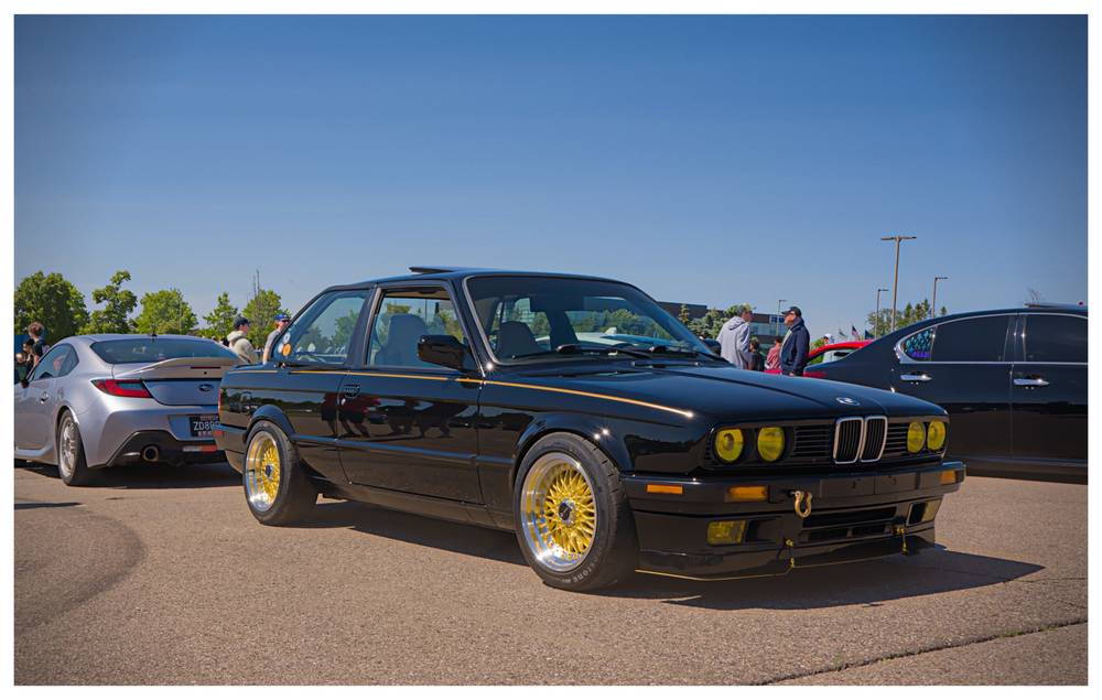Three quarter view of a square body black BMW with yellow/gold accents