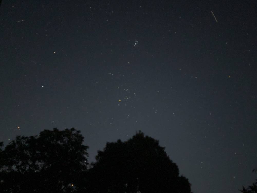 Similar photo, a night sky with many stars, and on the upper right is a shooting star.