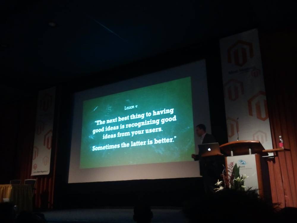 A stage slide reads a quote about recognizing good ideas from users.