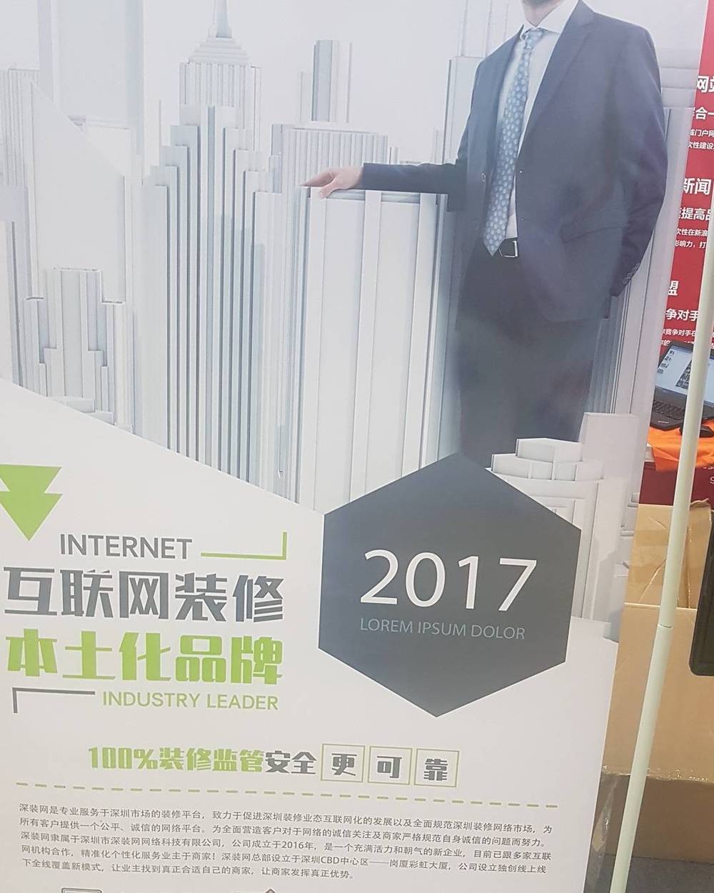 A life-size cardboard cutout of a businessman promoting a Chinese home renovation brand, dated 2017.