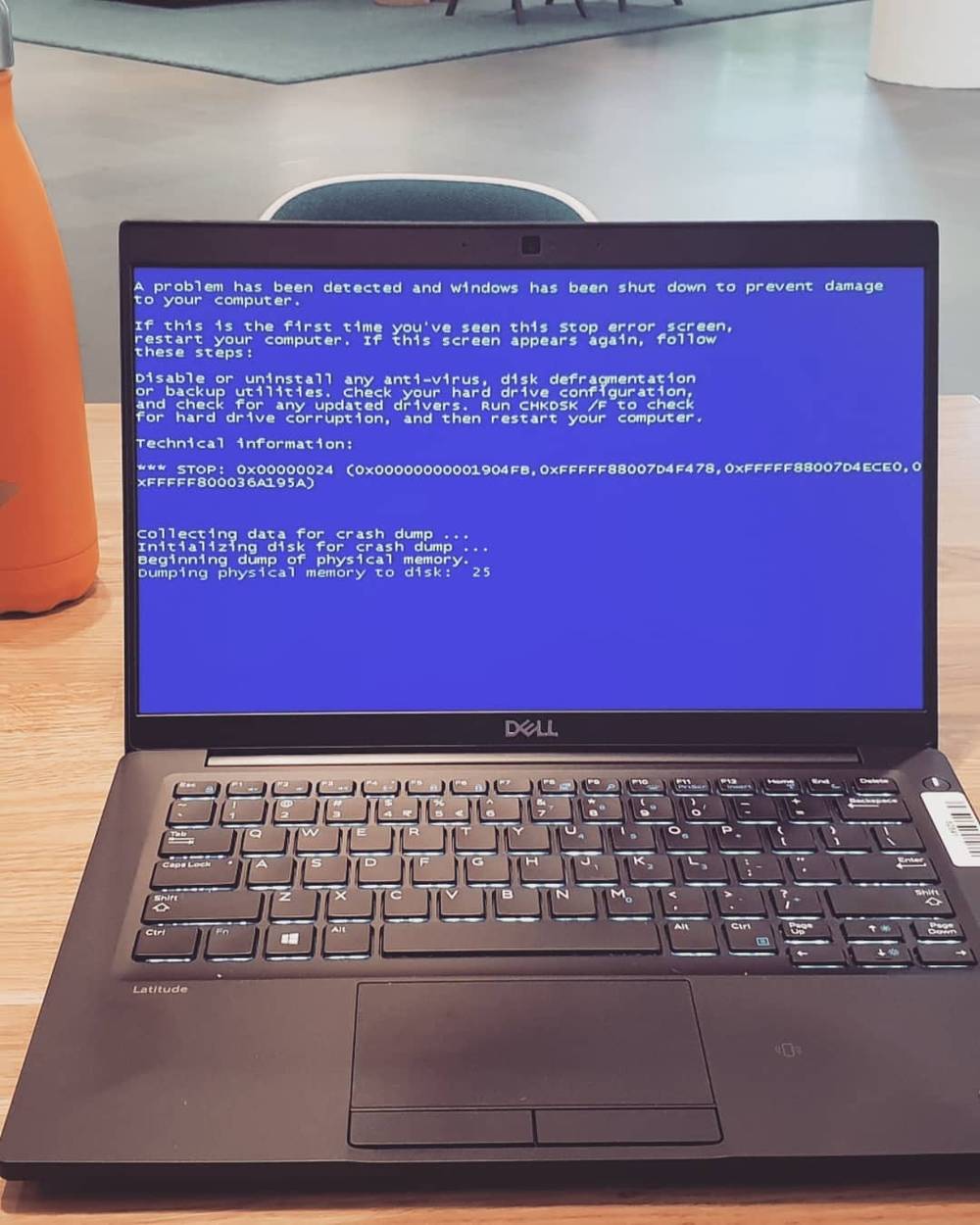 A laptop showing a Windows blue screen crash error.