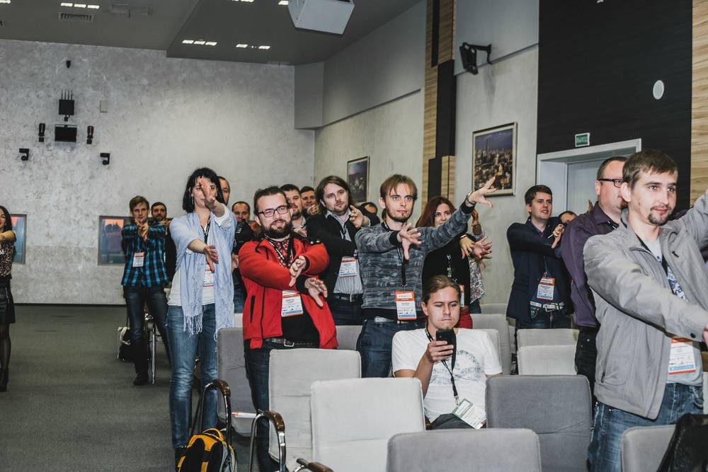 Conference attendees point together in the same direction during an exercise.