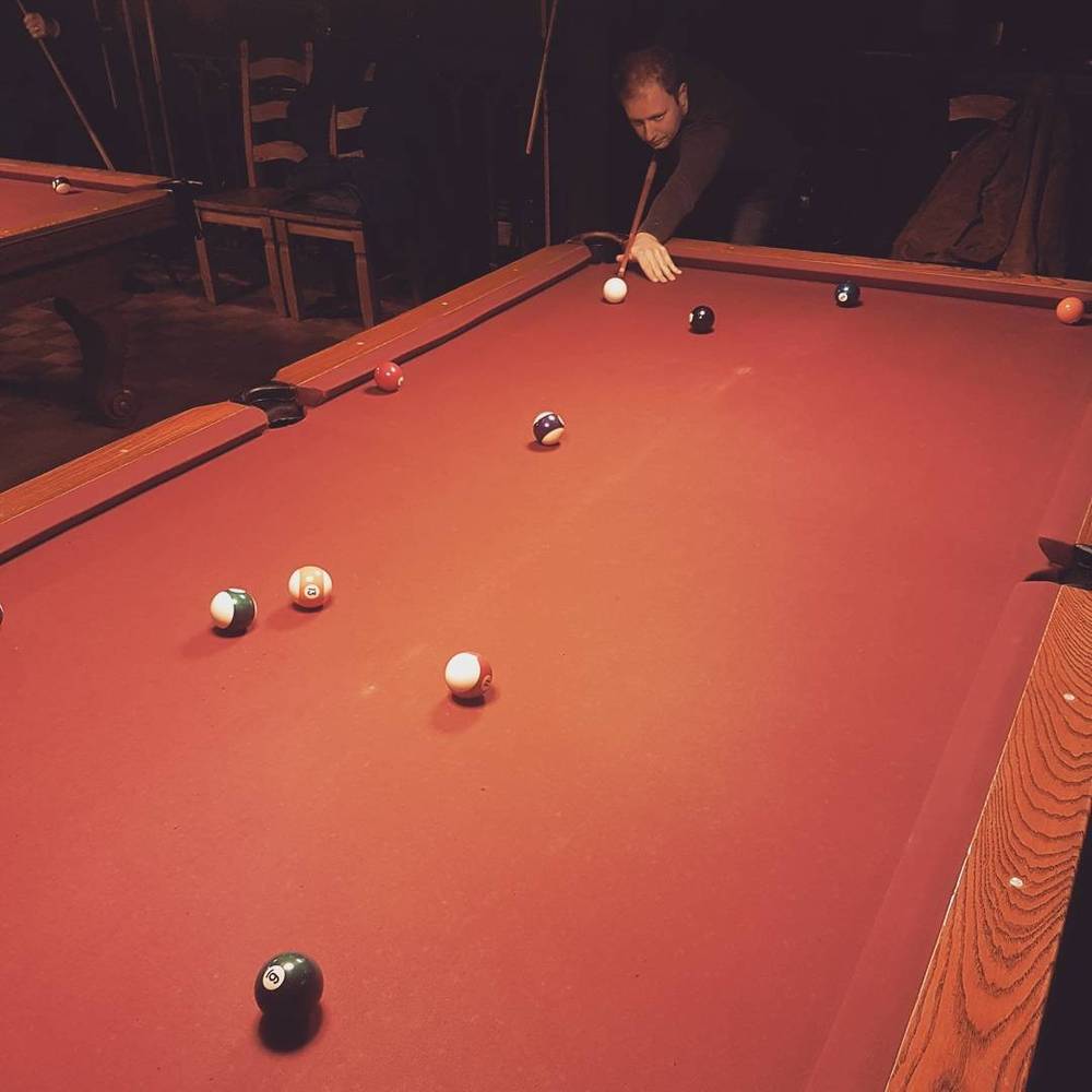 A pool table with balls scattered mid-game.