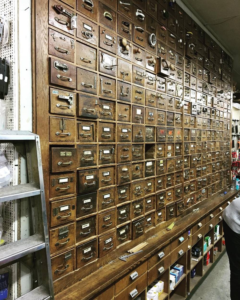 A wall of small vintage wooden drawers, like an old apothecary or hardware cabinet.