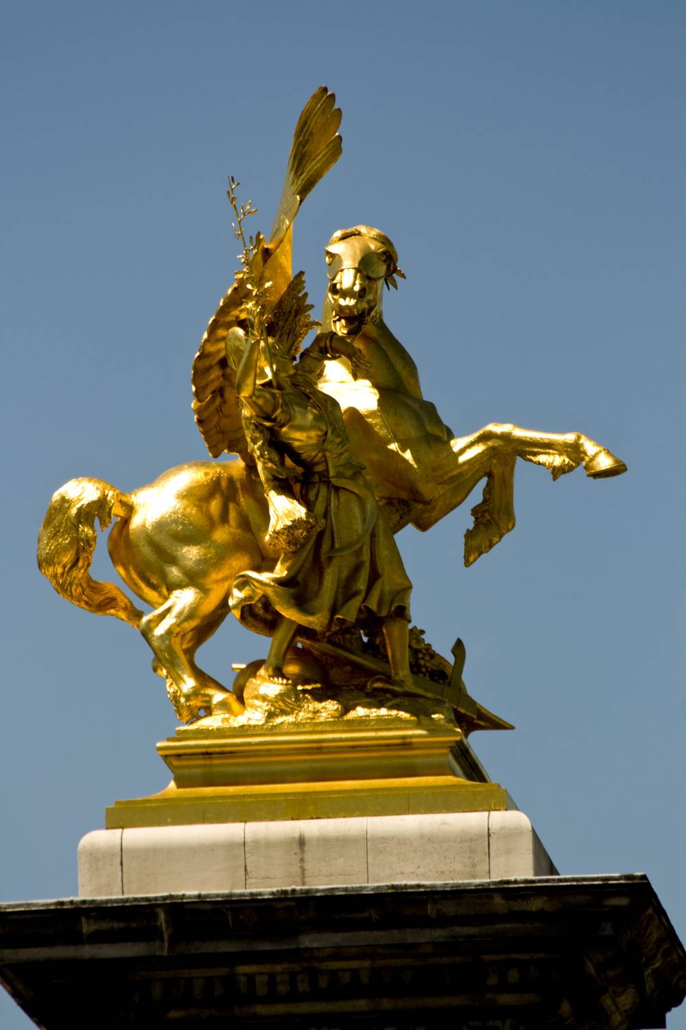 A golden winged horse statue with a rider stands atop the bridge's pillar.