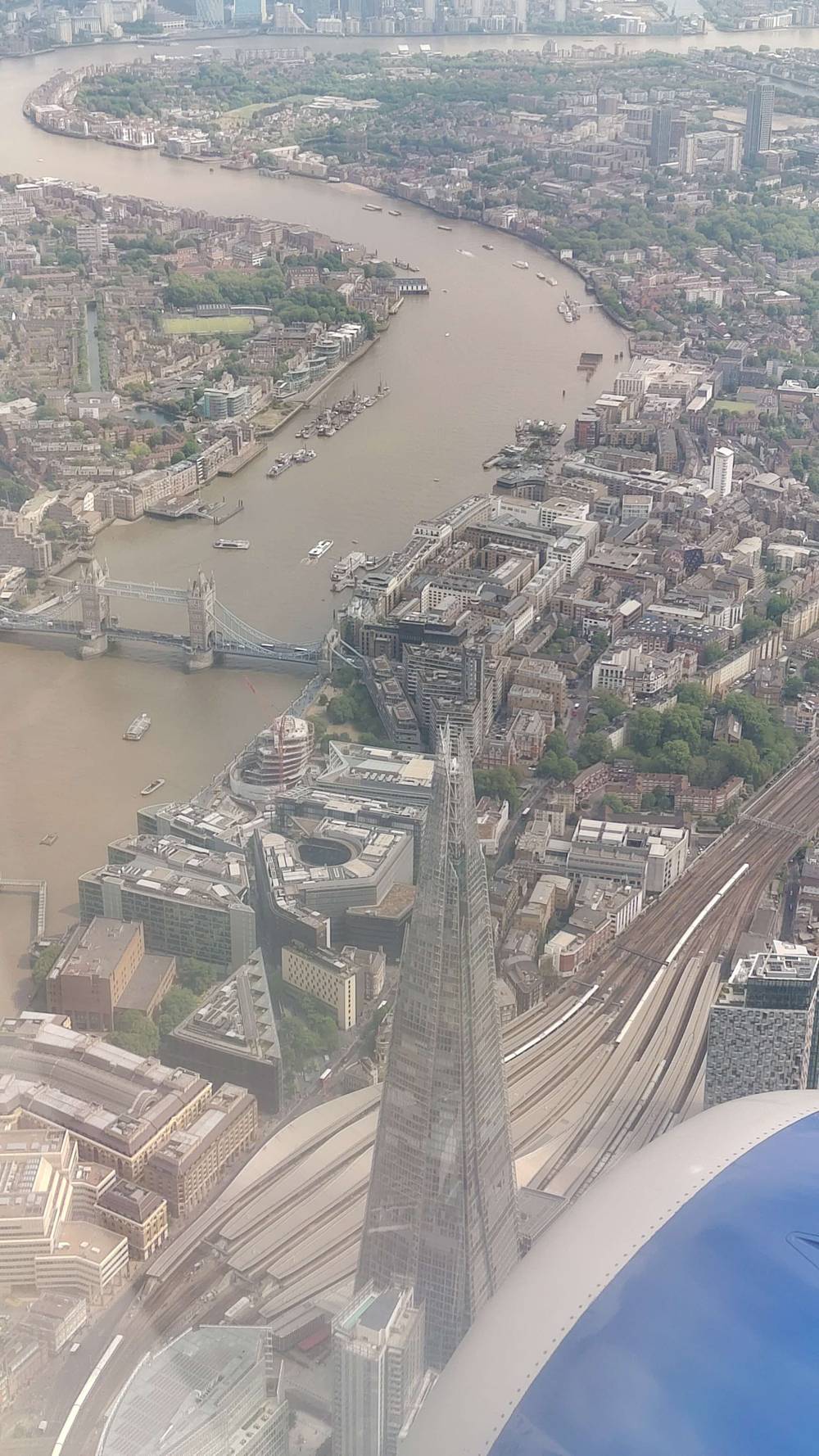 Aerial view over London showing the Thames river and the Shard skyscraper.