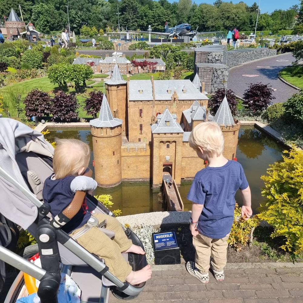 Two children looking at a miniature moated castle model at Madurodam.