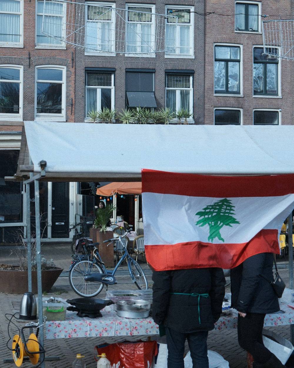 two people behind lebanese flag at market stall in niewmarkt