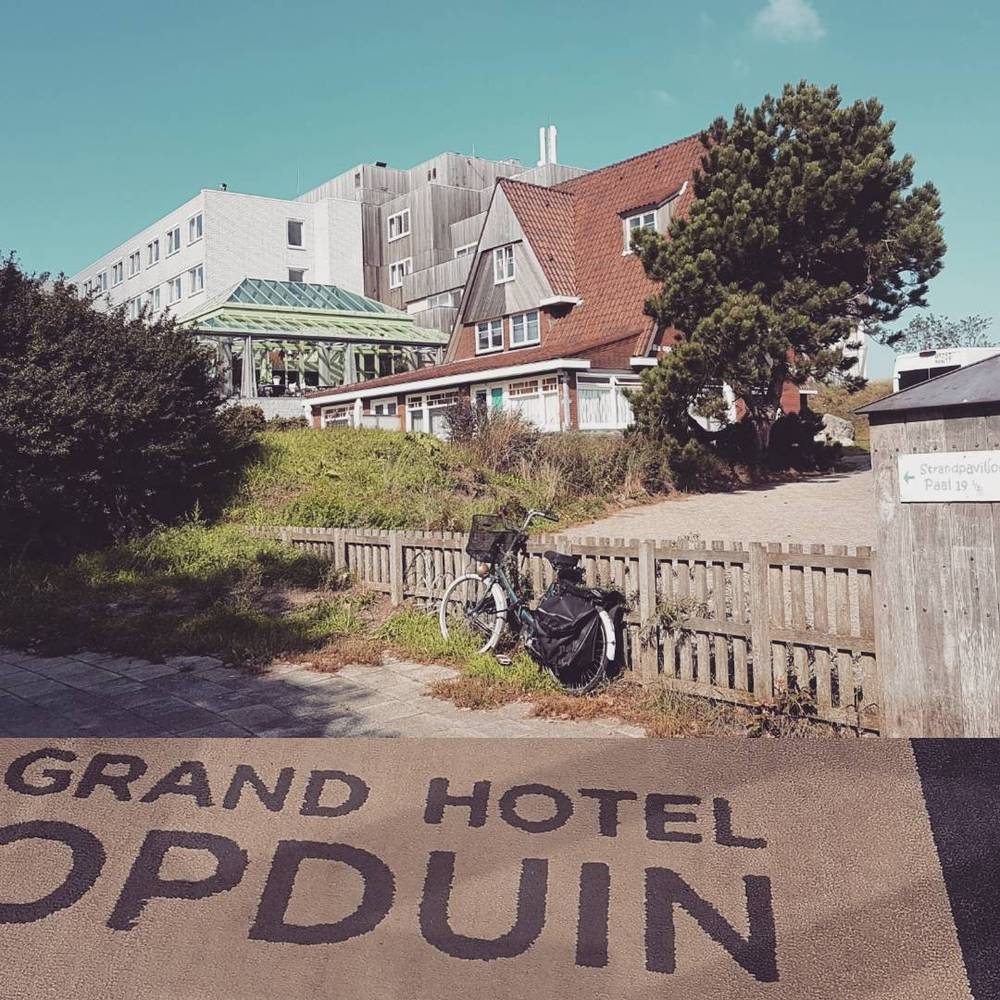 The exterior of the "Grand Hotel Opduin" on Texel, with a bicycle parked near the entrance.