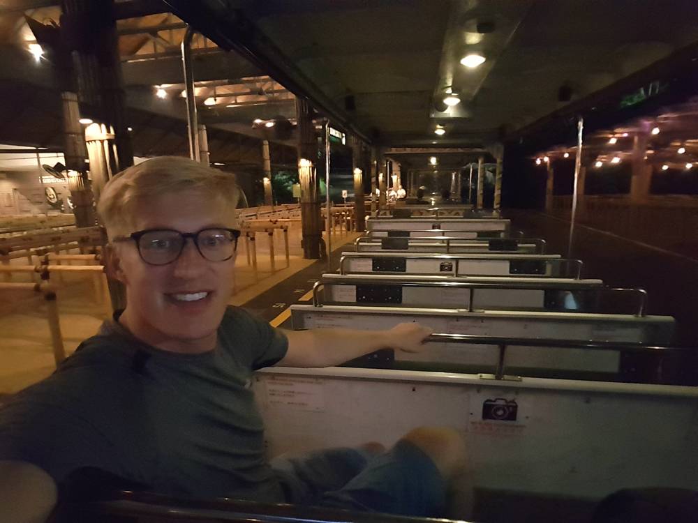 Guido smiles from his seat on an open-air tram at night.
