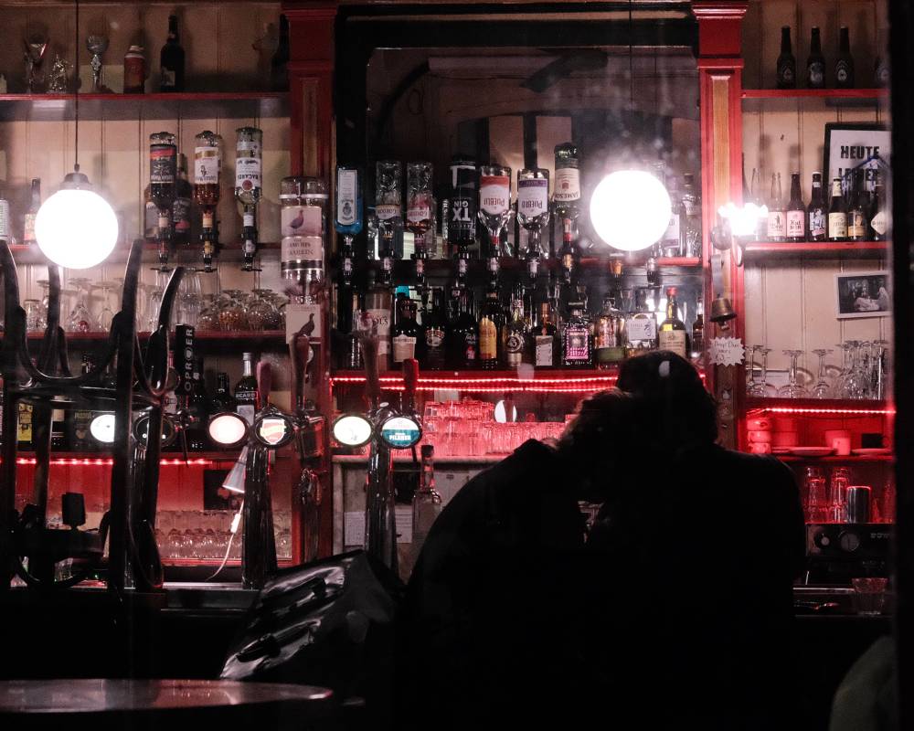 A couple shares an intimate moment in a closed bar
