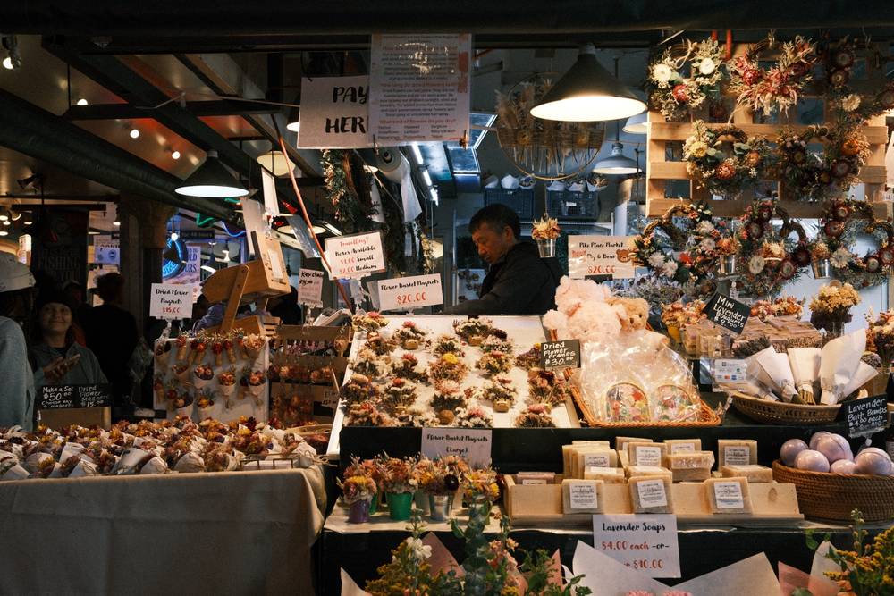 A merchant behind his counter filled with dried flower displays