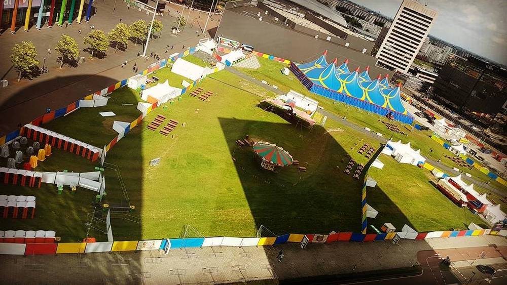 Aerial view of a circus-style event tent set up on a large lawn.